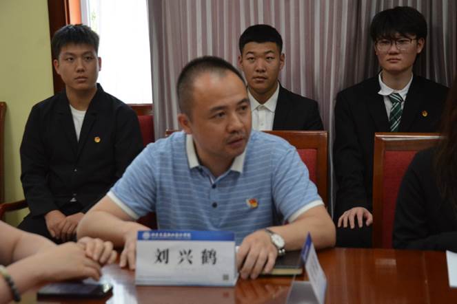 一群人坐在桌子前描述已自动生成 一群人坐在桌子前描述已自动生成